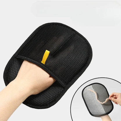 Hand wearing a black pet hair removal glove while cleaning fabric